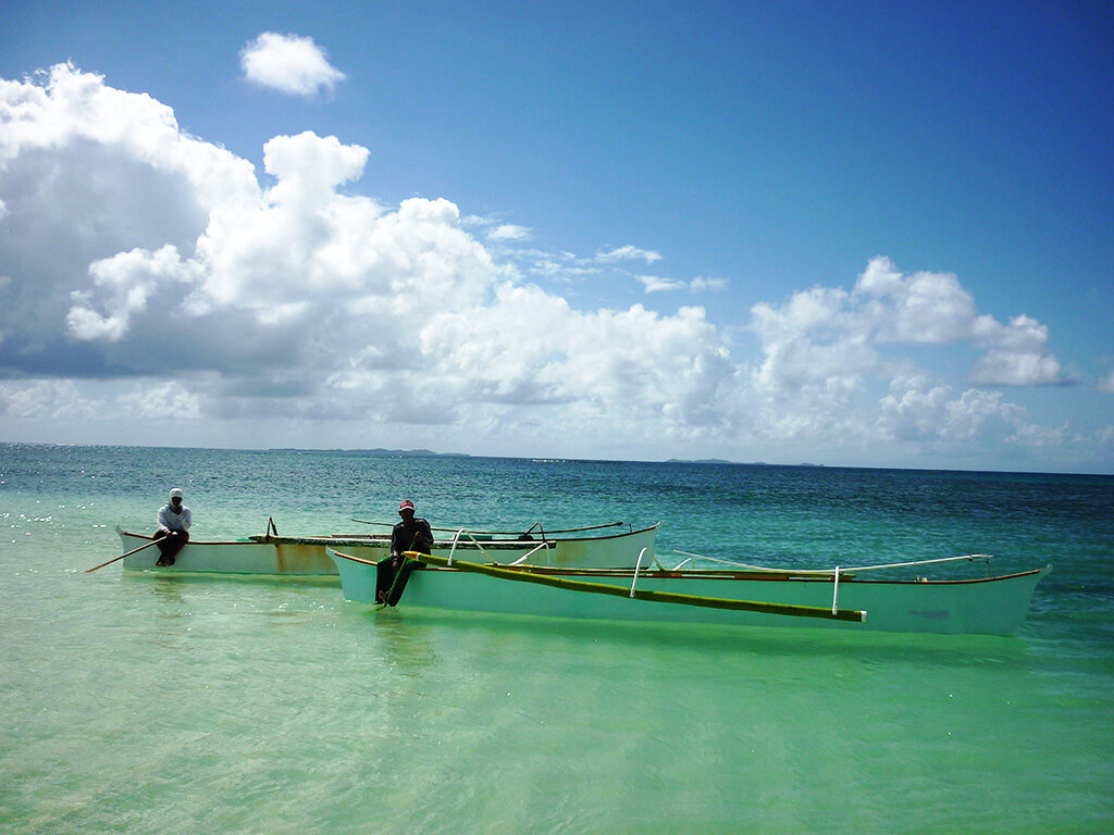 Bateau de pêche sur l'eau turquoise aux Philippines.