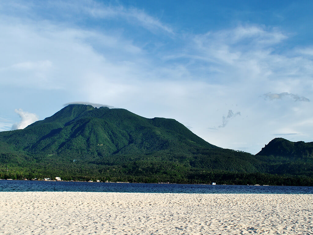 Vue sur les Montagnes depuis la plage de sable blanc dans les régions Camiguin et Siargao.